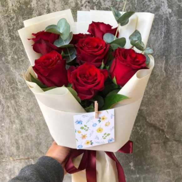 Букет из 7 красных роз с веточками эвкалипта в белой упаковке
