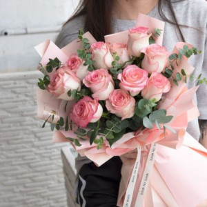 Букет из 11 розовых роз с веточками эвкалипта и нежной упаковкой