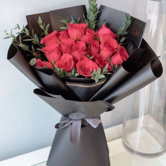 Букет 15 красных роз в черной упаковке с зеленью в Москве